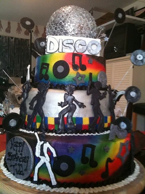 3-tier disco themed birthday cake with rainbow airbrushed tiers, silver disco ball topper, and black fondant dancer silhouettes. 3-tier disco themed birthday cake with rainbow airbrushed tiers, silver disco ball topper, and black fondant dancer silhouettes.