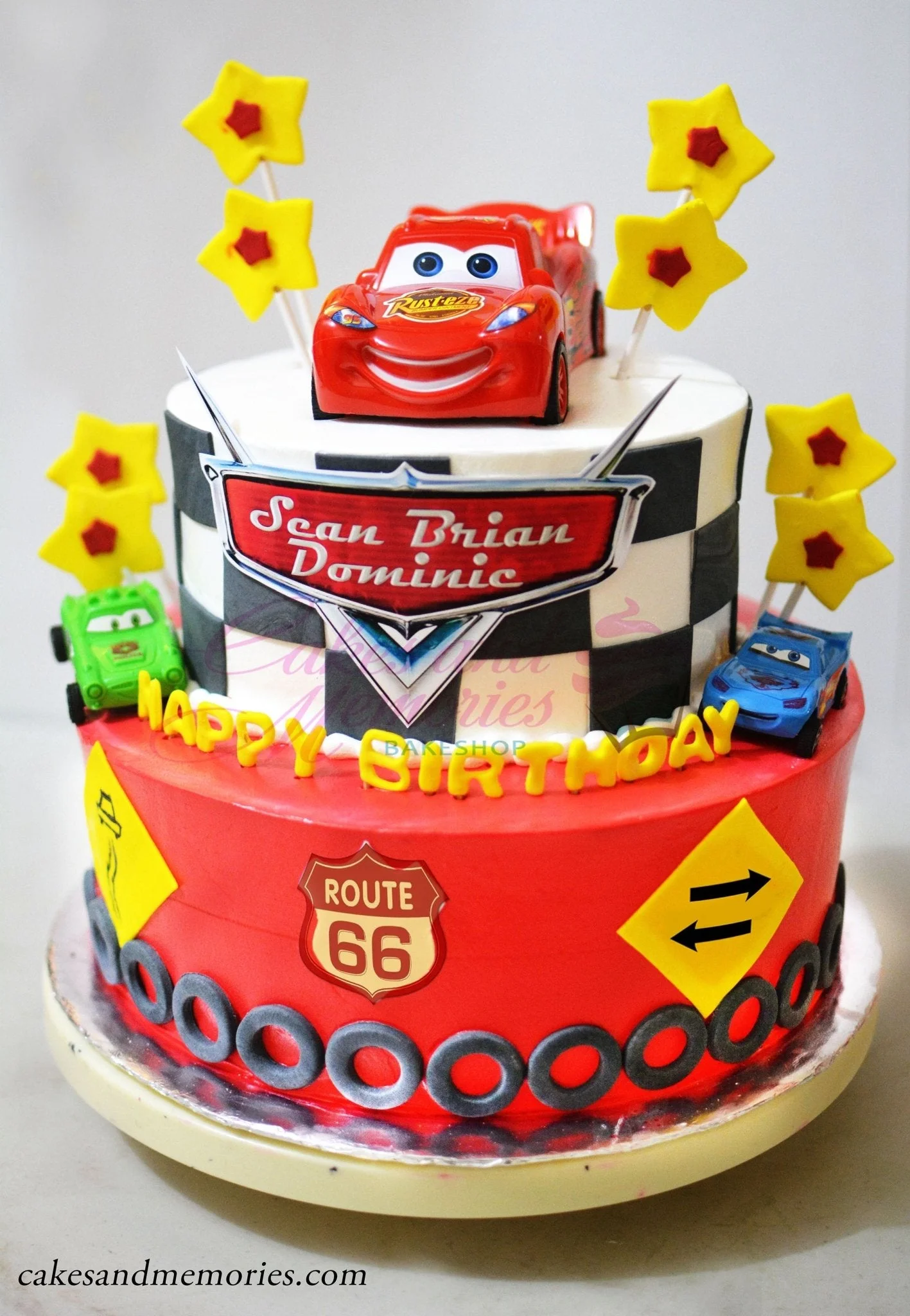 Disney-Inspired Cars 2-Tier Birthday Cake Two-tier Disney Cars themed birthday cake with Lightning McQueen toy topper, checkered pattern, and red icing.