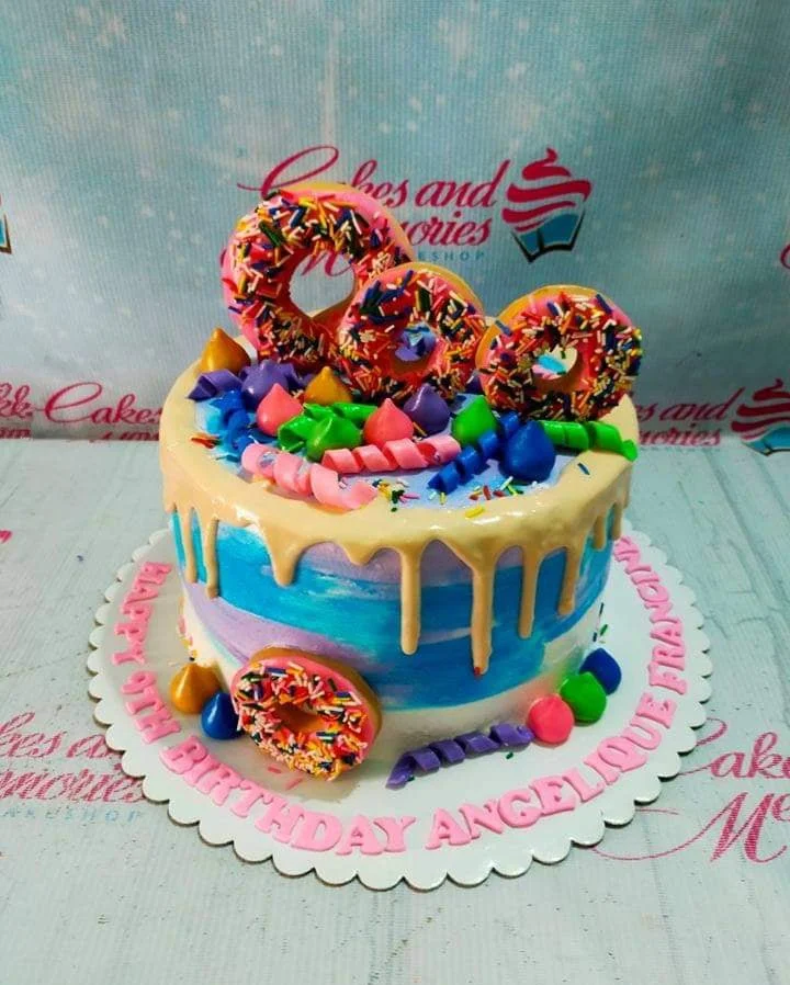 Donut Drip Birthday Cake A blue, purple, and white 1 Tier cake themed around Donut, featuring edible donut toppers and colorful icing swirls and sprinkles.