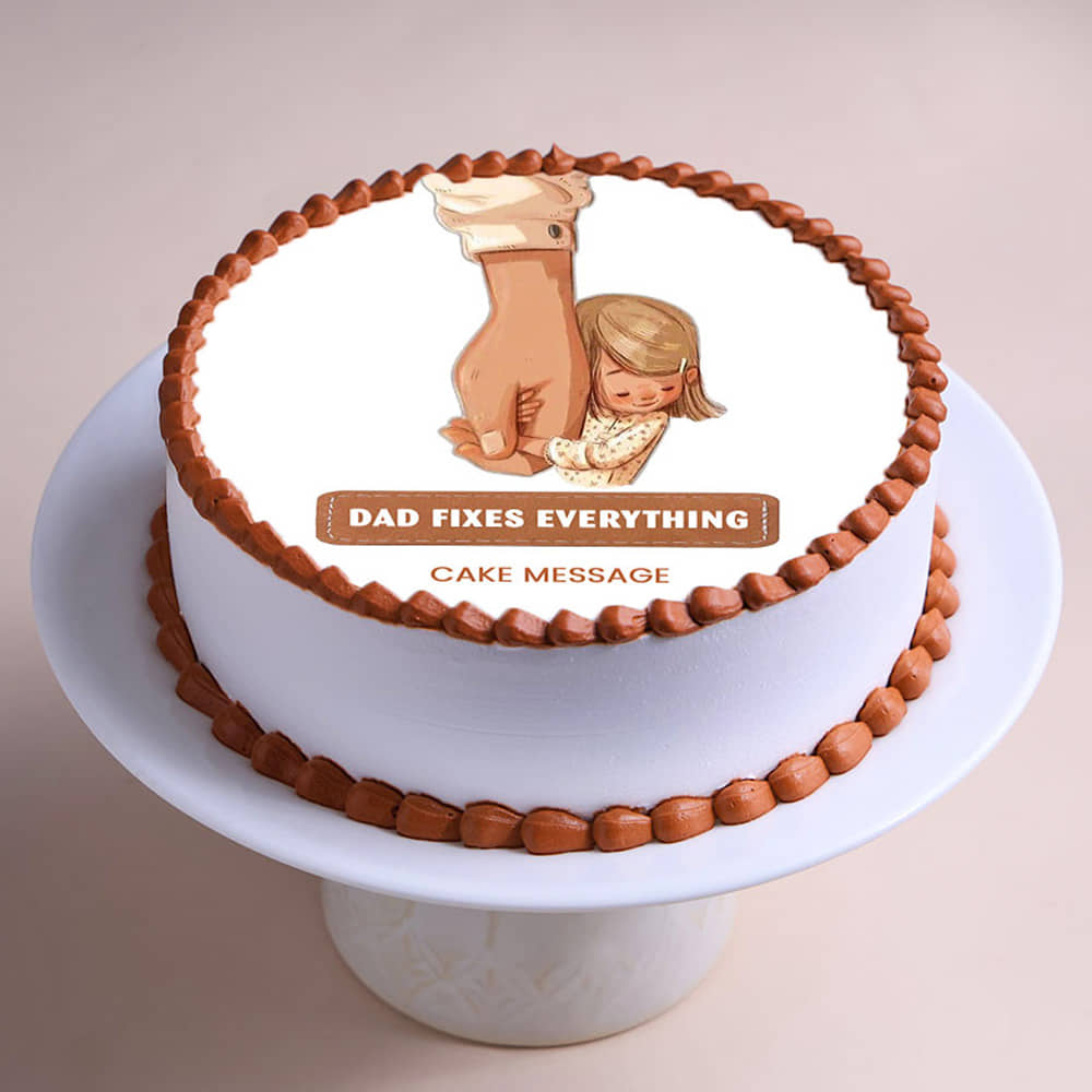 White round cake with brown piped borders and a printed image of a father holding a child's hand with the message Dad Fixes Everything. White round cake with brown piped borders and a printed image of a father holding a child's hand with the message Dad Fixes Everything.