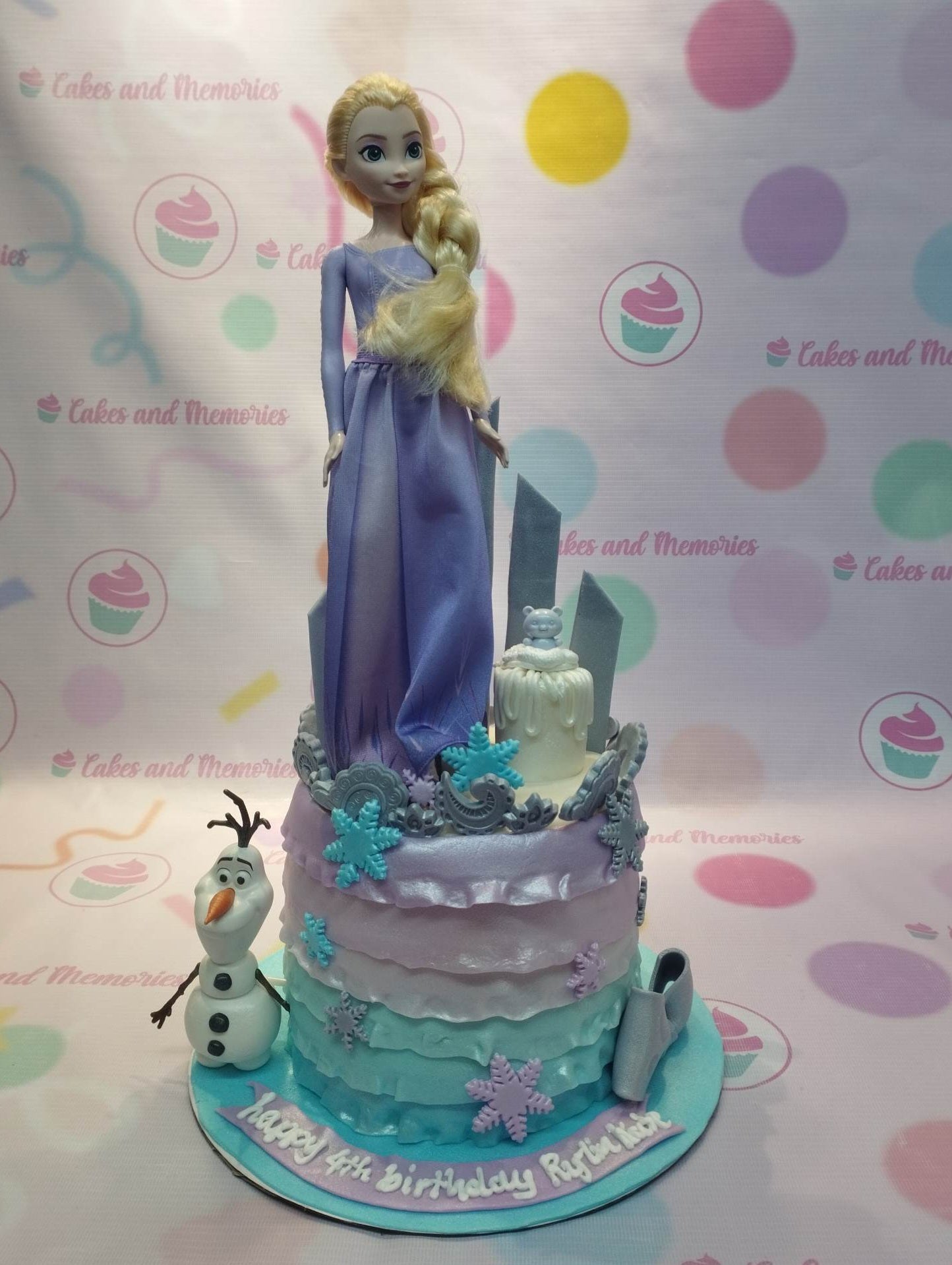 Frozen themed Elsa and Olaf cake with purple and teal ruffles, snowflakes, and a doll topper. Frozen themed Elsa and Olaf cake with purple and teal ruffles, snowflakes, and a doll topper.