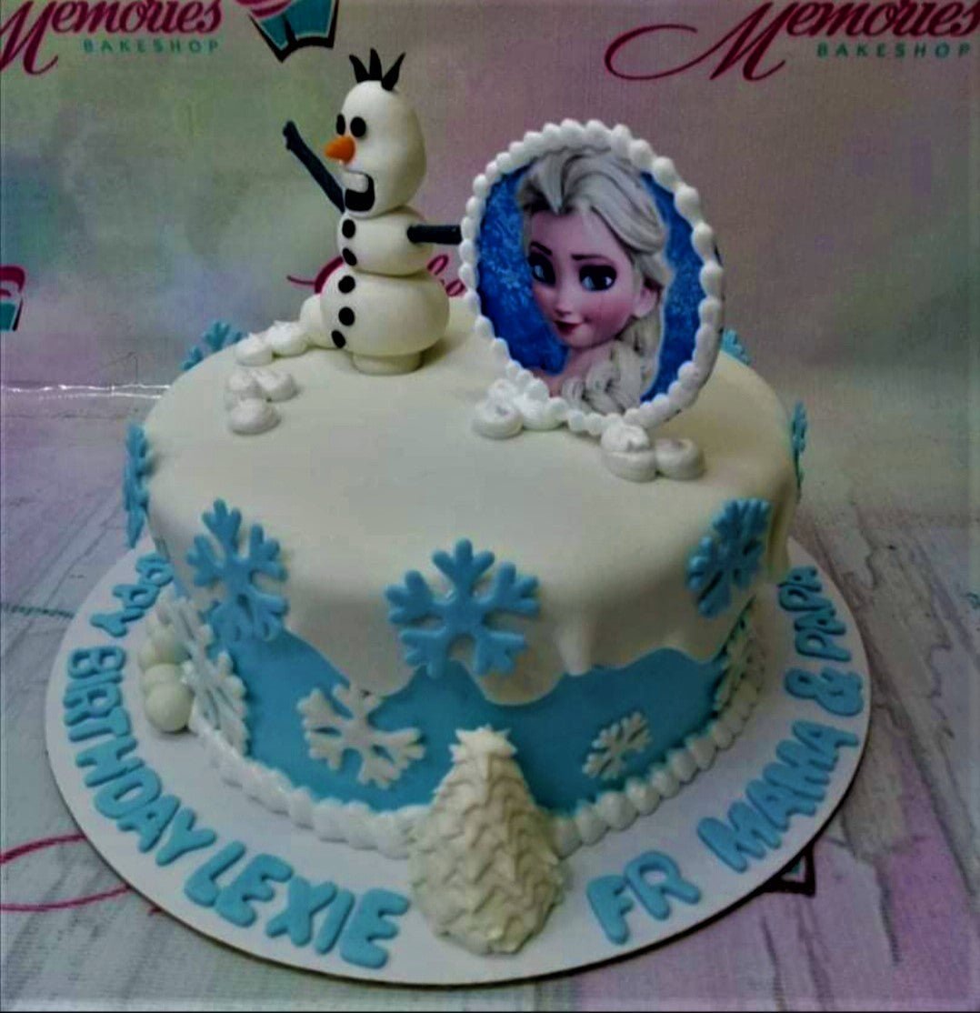 Frozen themed birthday cake with Olaf figurine, Elsa printout, and blue fondant snowflakes on a white and blue base. Frozen themed birthday cake with Olaf figurine, Elsa printout, and blue fondant snowflakes on a white and blue base.