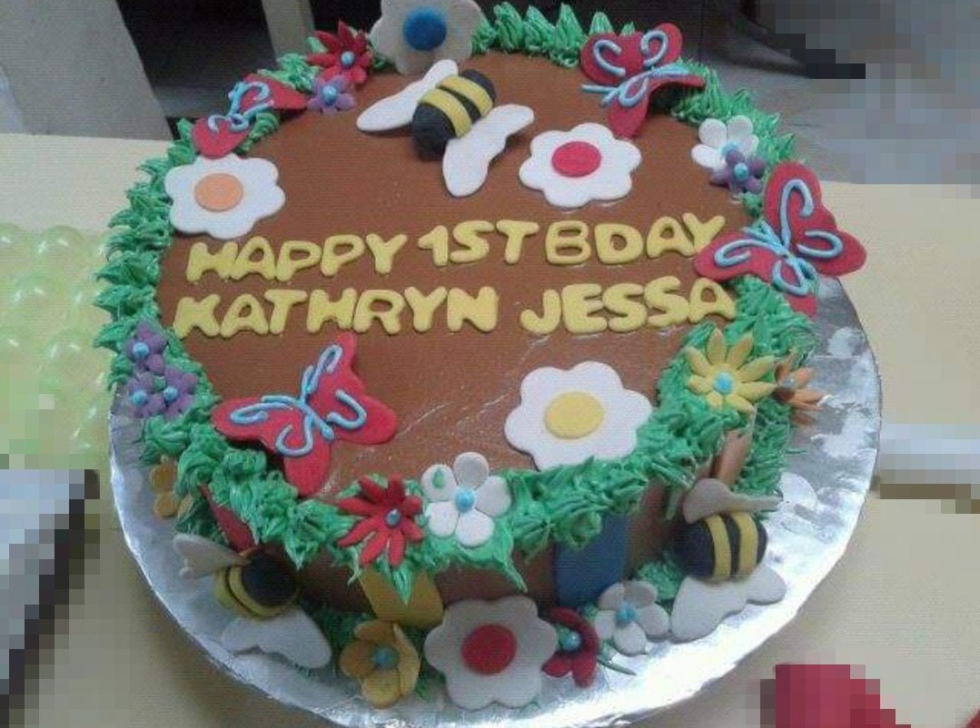 Brown soft-icing garden cake with green grass borders, fondant bees, butterflies, and flowers for a 1st birthday. Brown soft-icing garden cake with green grass borders, fondant bees, butterflies, and flowers for a 1st birthday.