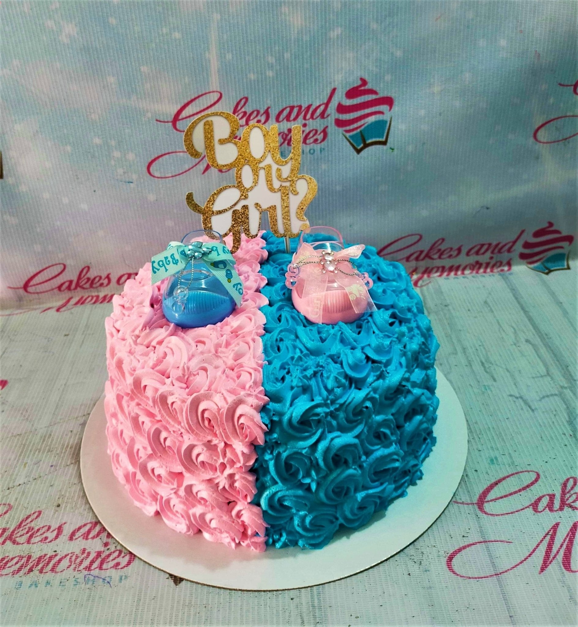 Gender reveal cake with pink and blue icing rosettes, gold Boy or Girl topper, and baby shoe decorations. Gender reveal cake with pink and blue icing rosettes, gold Boy or Girl topper, and baby shoe decorations.