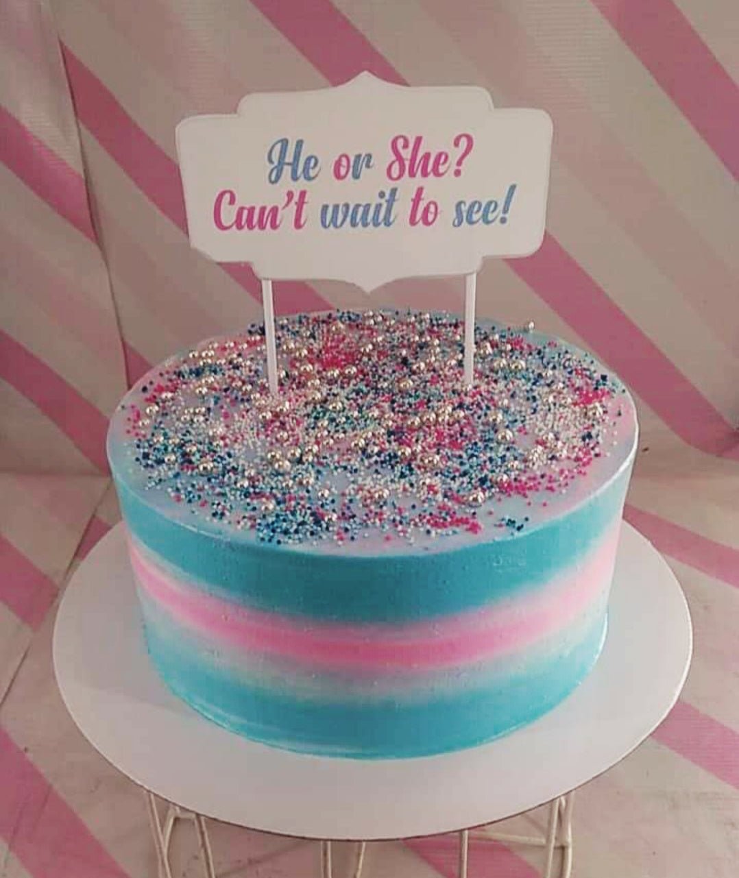 Gender reveal cake with blue and pink gradient icing, silver dragees, and a 'He or She? Can't wait to see!' topper. Gender reveal cake with blue and pink gradient icing, silver dragees, and a 'He or She? Can't wait to see!' topper.