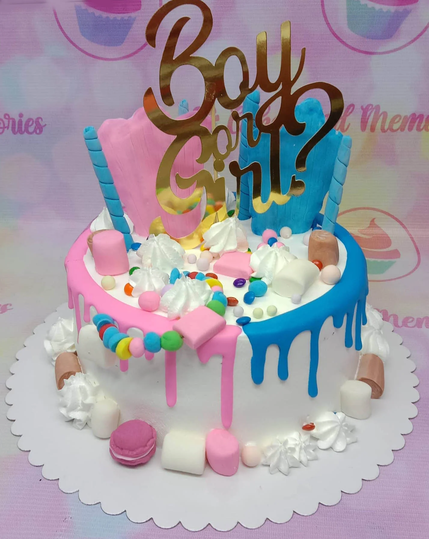 Gender Reveal Glitter Cake A white 1-Tier Gender Reveal cake with pink and blue drips, featuring a gold 'Boy or Girl?' topper, rosettes, and mixed candies.