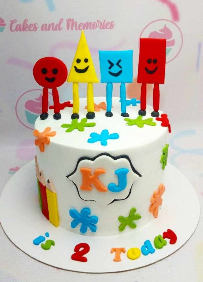 White fondant birthday cake with colorful 3D geometric shape characters and paint splatters for a 2nd birthday. White fondant birthday cake with colorful 3D geometric shape characters and paint splatters for a 2nd birthday.