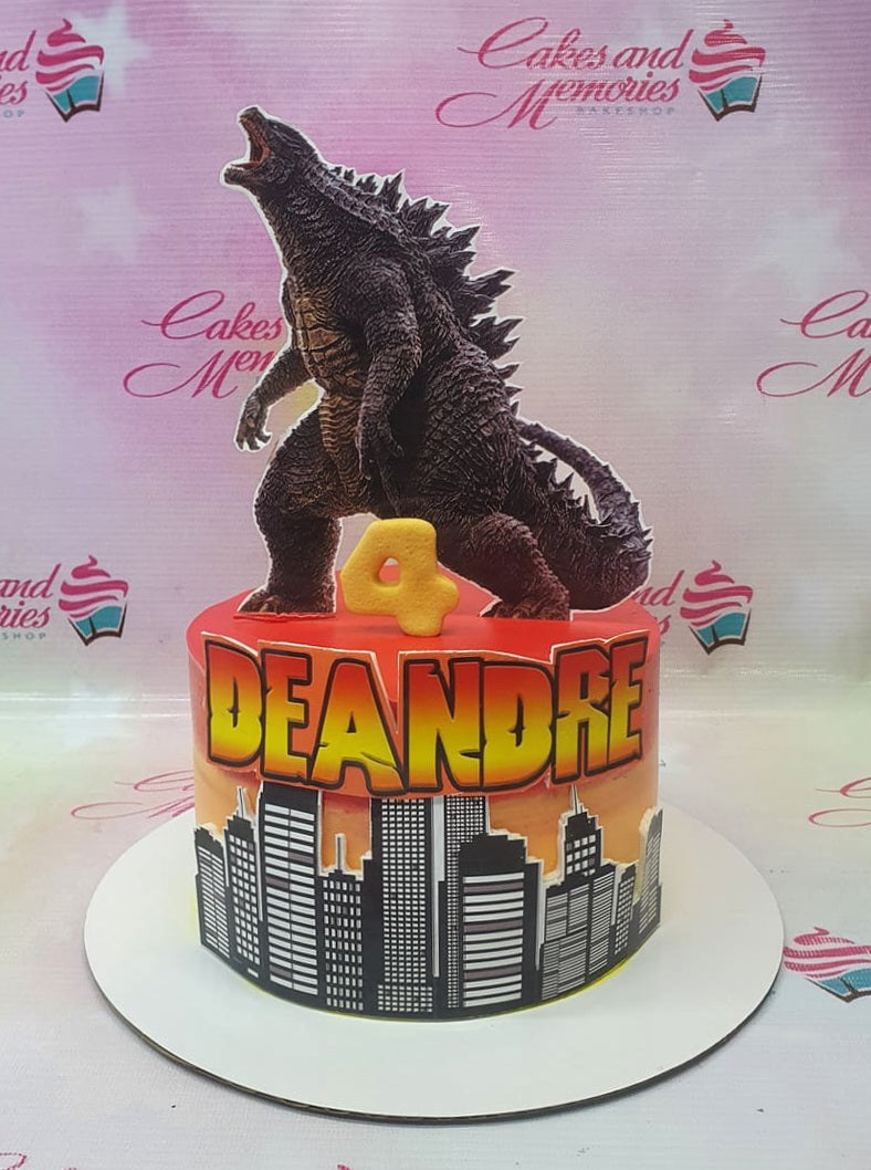 Godzilla themed birthday cake with a city skyline wrap and a large Godzilla cutout on top for Deandre's 4th birthday. Godzilla themed birthday cake with a city skyline wrap and a large Godzilla cutout on top for Deandre's 4th birthday.