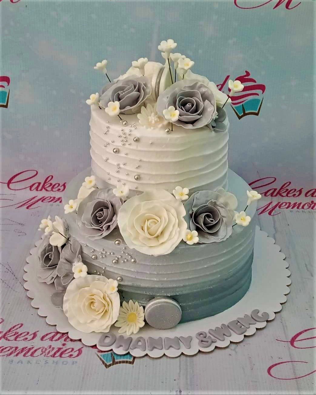 Elegant 2-tier white and gray ombre cake decorated with large gray and white gumpaste roses and silver dragees. Elegant 2-tier white and gray ombre cake decorated with large gray and white gumpaste roses and silver dragees.