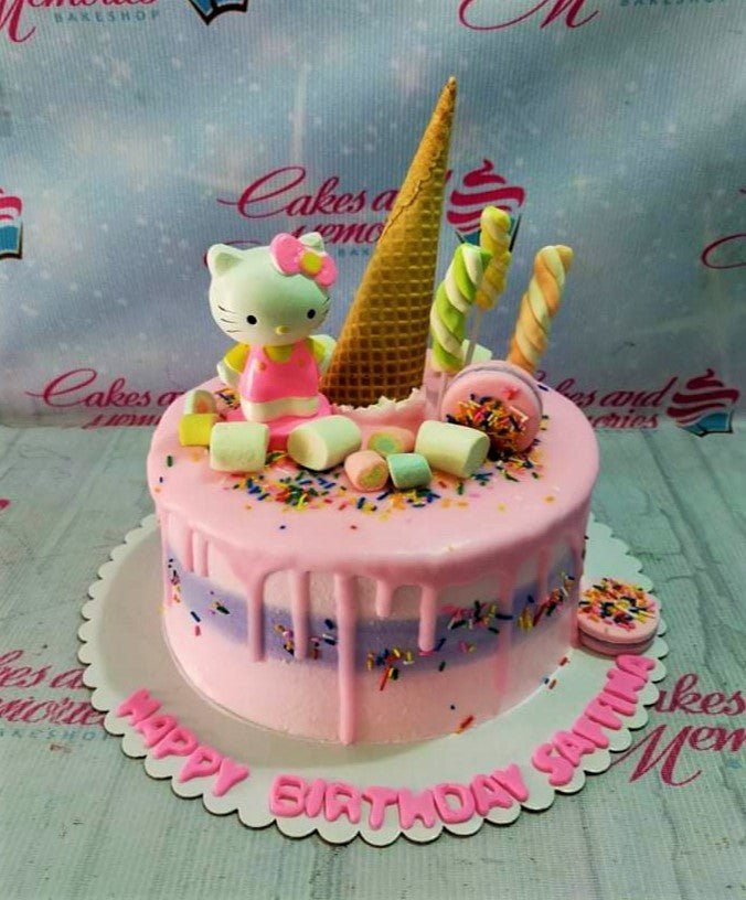 Pink Hello Kitty birthday cake with a pink drip, colorful sprinkles, marshmallows, and a waffle cone topper. Pink Hello Kitty birthday cake with a pink drip, colorful sprinkles, marshmallows, and a waffle cone topper.