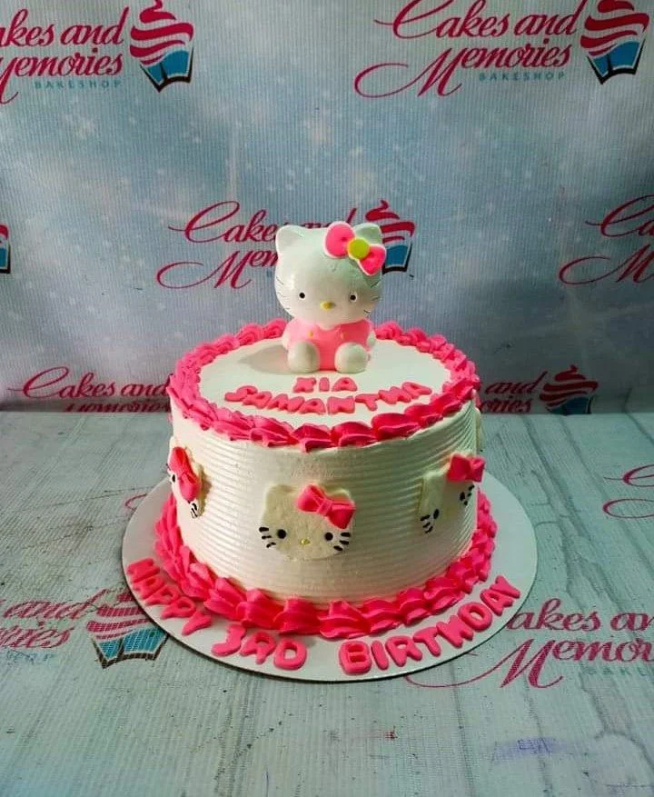 White Hello Kitty birthday cake with pink icing borders and a 3D Hello Kitty topper.
