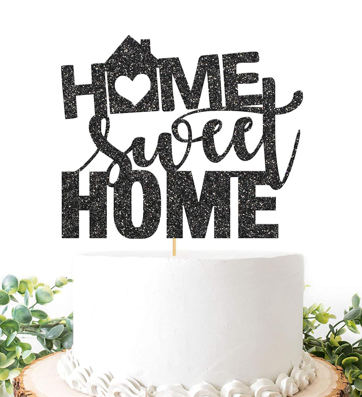 White minimalist cake with a large black glittery Home Sweet Home topper featuring a house and heart design. White minimalist cake with a large black glittery Home Sweet Home topper featuring a house and heart design.