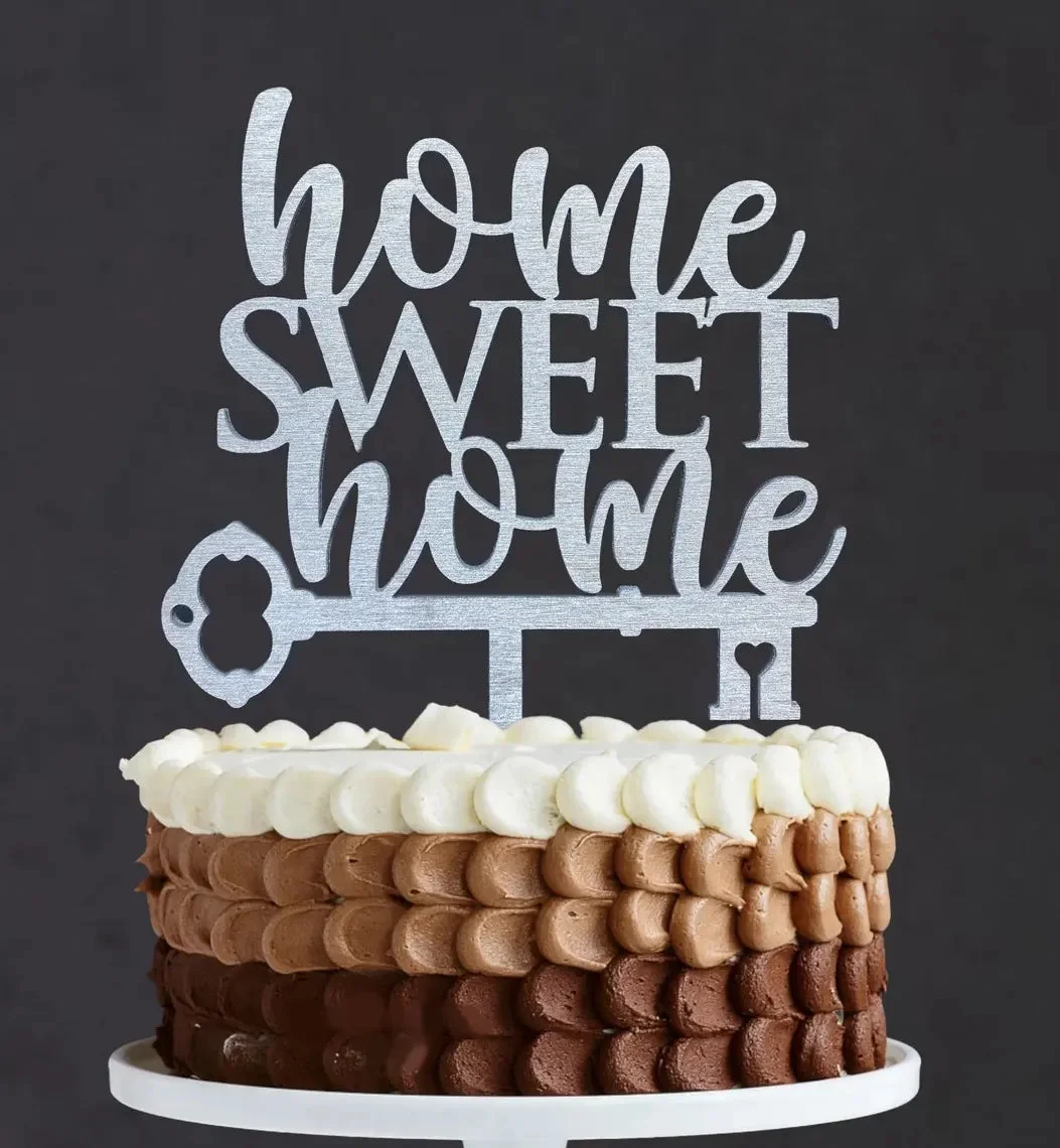 Single tier chocolate and vanilla ombre cake with a silver Home Sweet Home key topper and white icing dollops. Single tier chocolate and vanilla ombre cake with a silver Home Sweet Home key topper and white icing dollops.