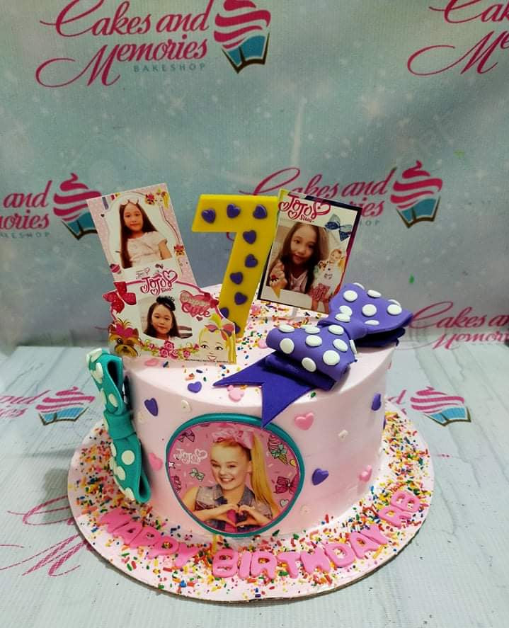 Pink JoJo Siwa themed birthday cake with photo printouts, a large purple bow, and colorful sprinkles. Pink JoJo Siwa themed birthday cake with photo printouts, a large purple bow, and colorful sprinkles.