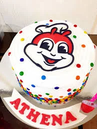 White round cake with Jollibee character printout on top and colorful icing dots on the sides. White round cake with Jollibee character printout on top and colorful icing dots on the sides.
