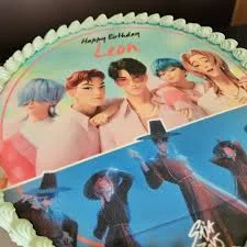 K-pop themed birthday cake for Leon featuring a large edible photo print of a boy group and mint green icing borders.