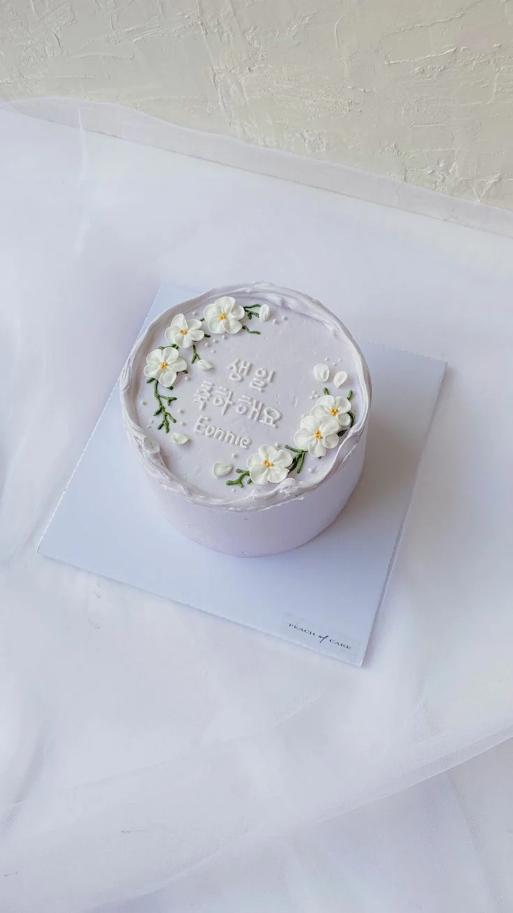 Lavender minimalist bento cake with white piped icing flowers and Korean birthday message