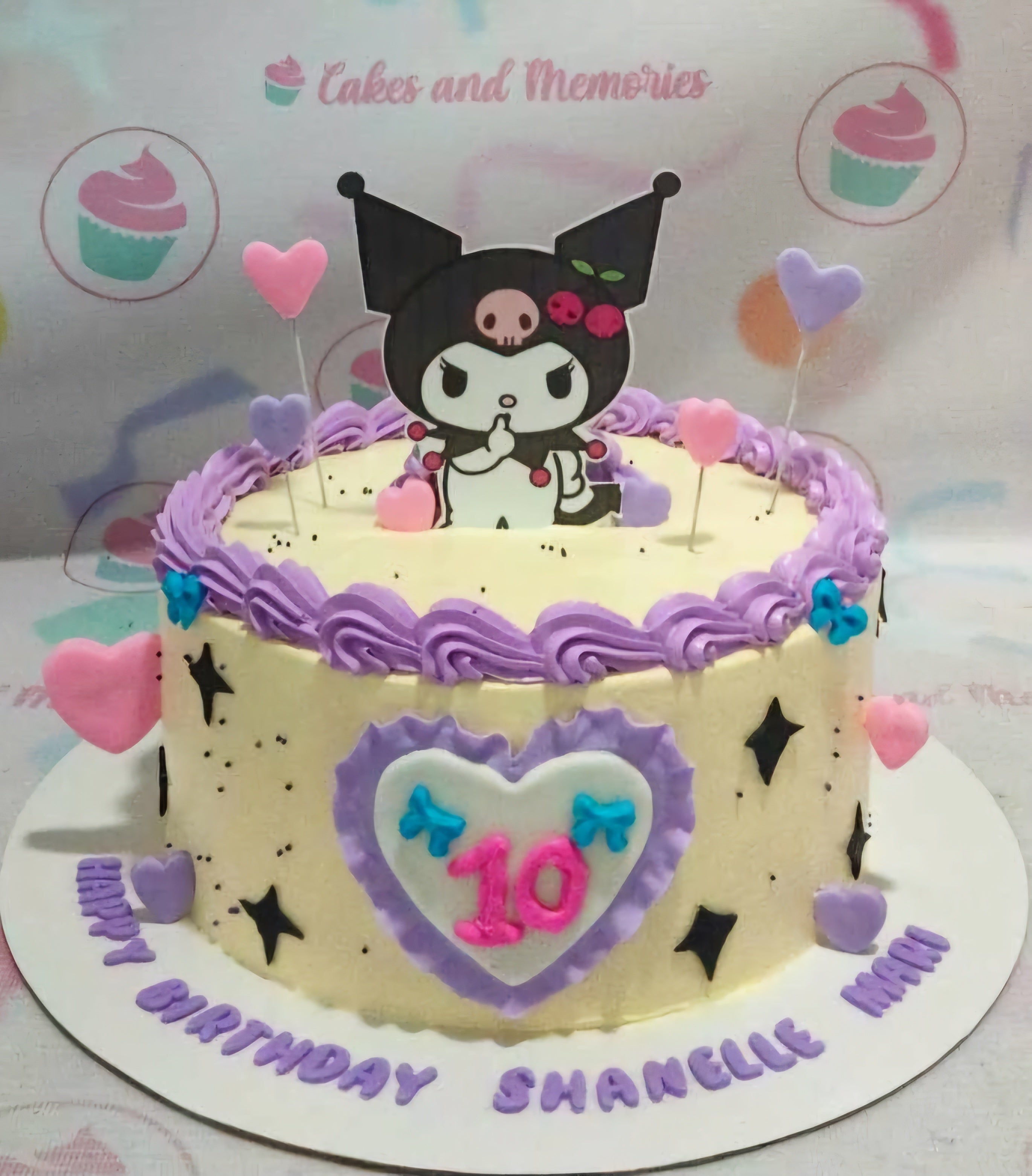 Kuromi themed birthday cake with purple icing borders, pink and purple hearts, and a Kuromi character topper. Kuromi themed birthday cake with purple icing borders, pink and purple hearts, and a Kuromi character topper.