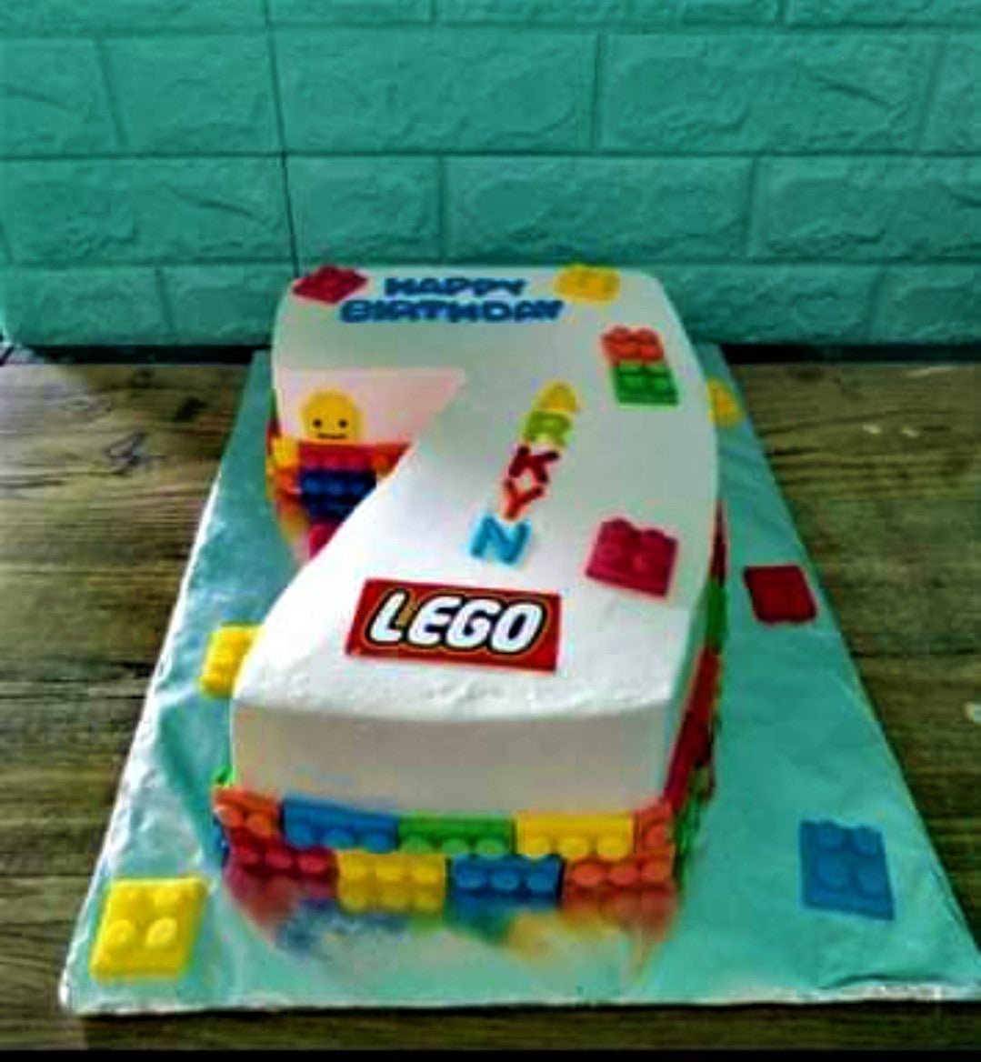 Number 7 shaped Lego themed birthday cake with colorful edible Lego bricks and printed Lego logo. Number 7 shaped Lego themed birthday cake with colorful edible Lego bricks and printed Lego logo.