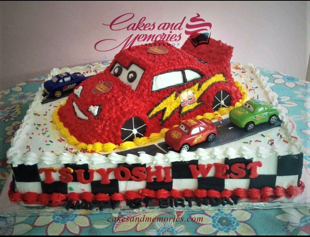 Lightning McQueen themed rectangle cake with toy cars and checkered flag pattern on the sides. Lightning McQueen themed rectangle cake with toy cars and checkered flag pattern on the sides.