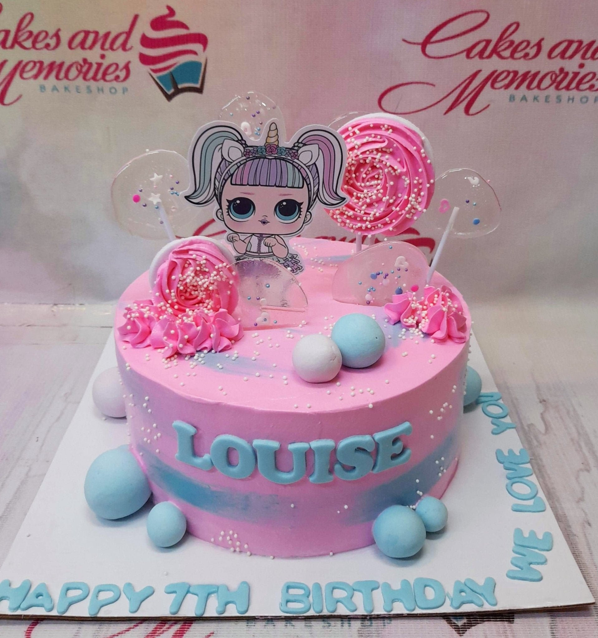 Pink LOL Surprise themed birthday cake with pink meringue pops, blue fondant balls, and a character printout topper. Pink LOL Surprise themed birthday cake with pink meringue pops, blue fondant balls, and a character printout topper.