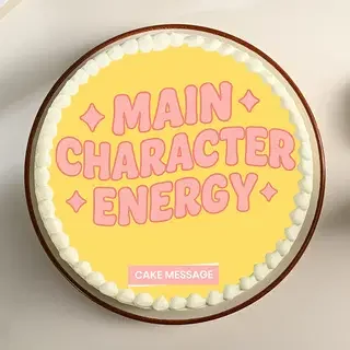 Yellow bento cake with white icing border and pink printed text reading Main Character Energy. Yellow bento cake with white icing border and pink printed text reading Main Character Energy.