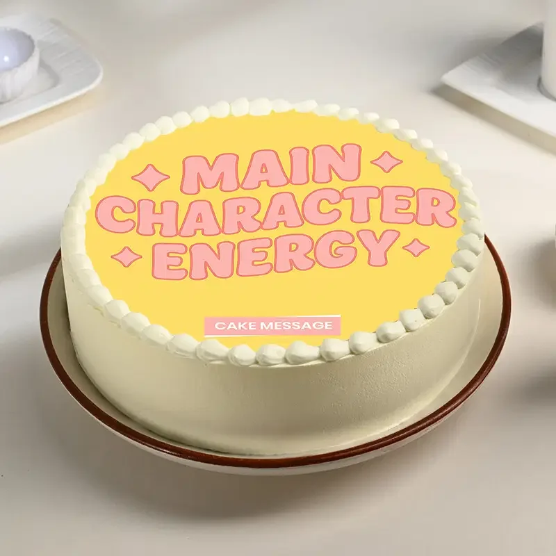 Yellow bento cake with white icing borders and pink 'Main Character Energy' text on top. Yellow bento cake with white icing borders and pink 'Main Character Energy' text on top.
