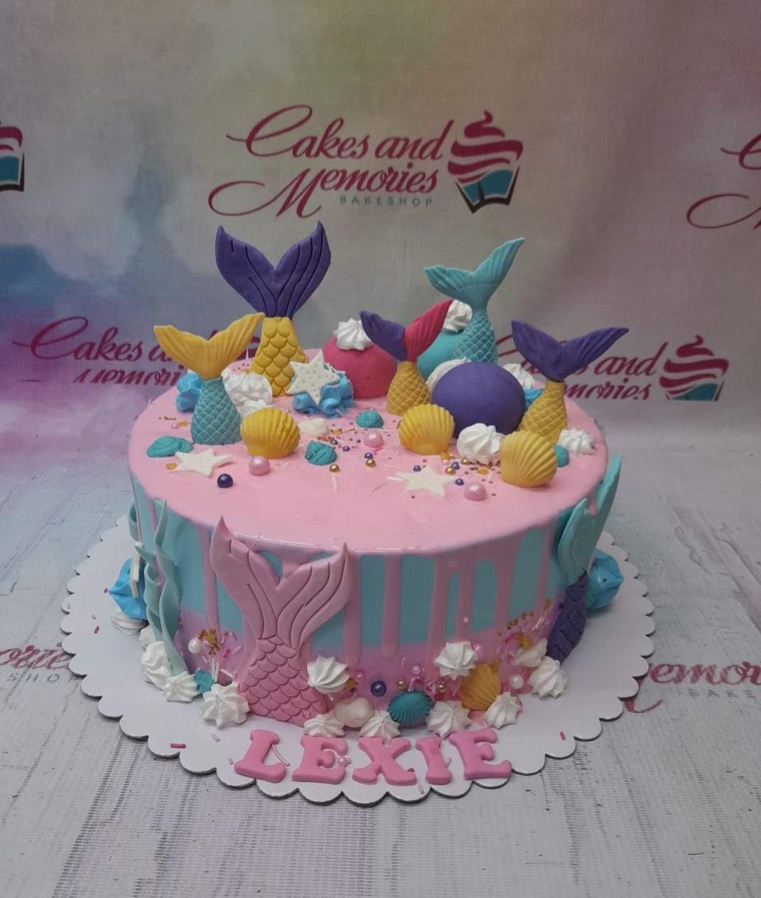 Pink and blue mermaid themed cake with colorful fondant mermaid tails, shells, and stars. Pink and blue mermaid themed cake with colorful fondant mermaid tails, shells, and stars.