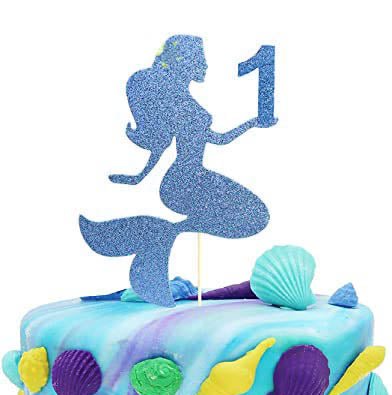Mermaid themed birthday cake with blue glitter mermaid topper and colorful fondant seashells on a blue and purple marbled icing base. Mermaid themed birthday cake with blue glitter mermaid topper and colorful fondant seashells on a blue and purple marbled icing base.