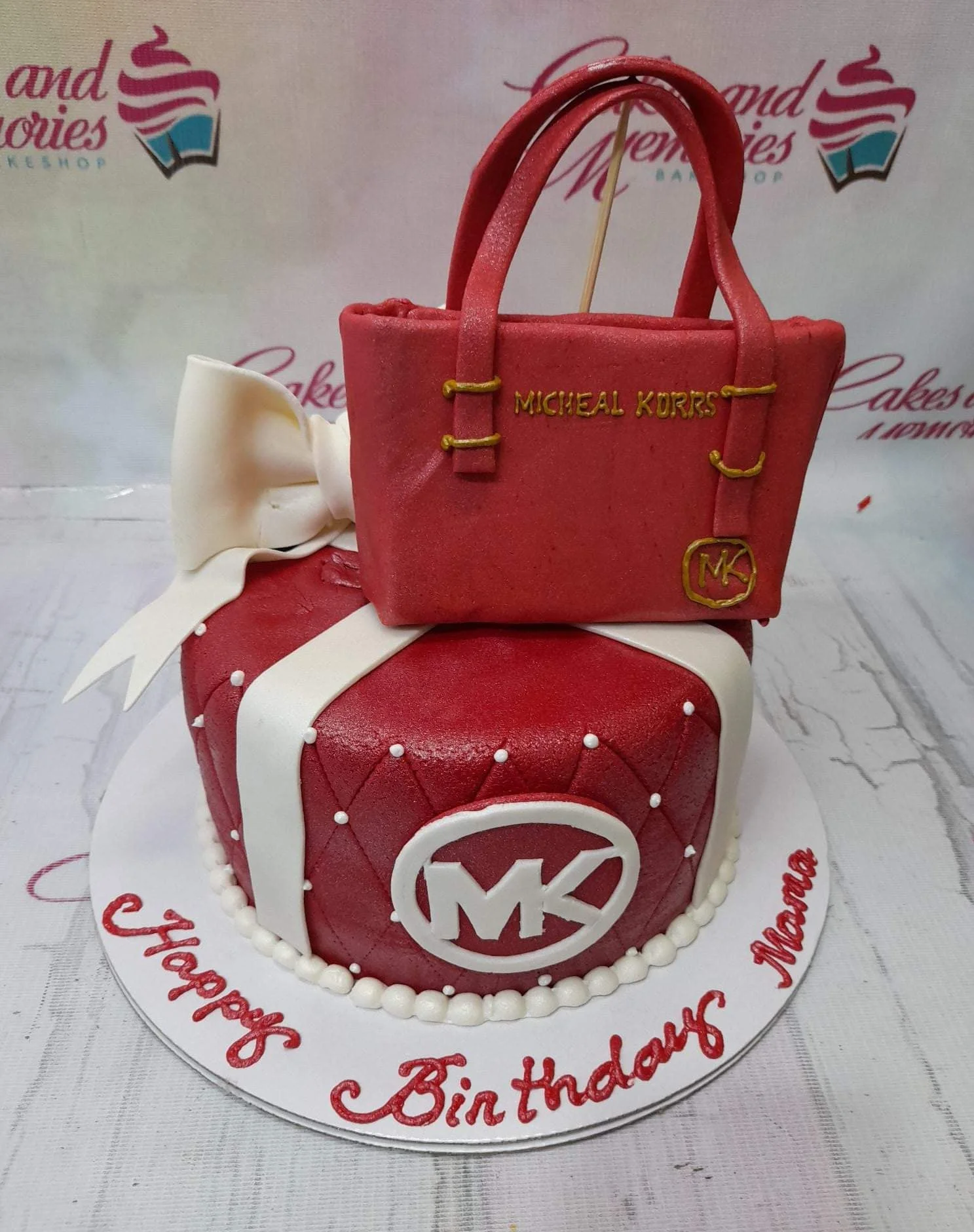 Michael Kors Red Bow Cake Red quilted fondant cake with a white bow and a 3D Michael Kors handbag topper.