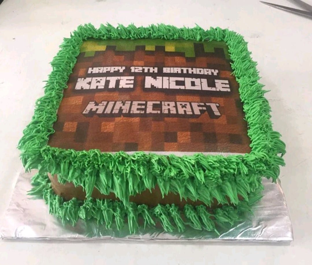 Square Minecraft themed birthday cake with brown dirt block icing and green grass piping borders featuring a printed edible topper. Square Minecraft themed birthday cake with brown dirt block icing and green grass piping borders featuring a printed edible topper.