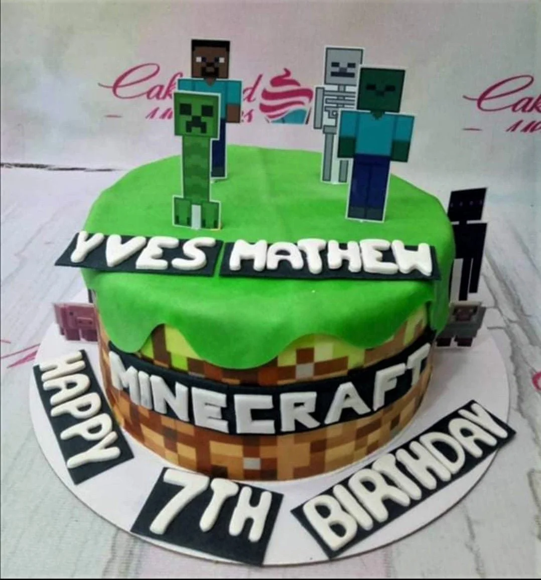 Minecraft themed birthday cake with green grass top, pixelated dirt sides, and character printouts of Steve, Creeper, and Zombie.