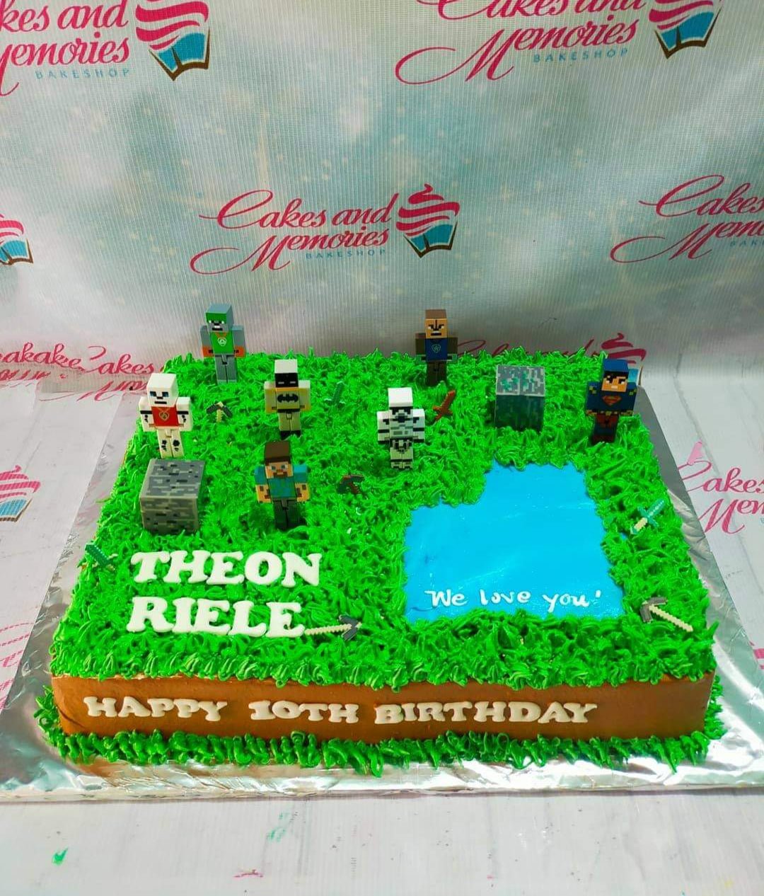 Minecraft themed rectangle cake with green grass icing, a blue water pond, and various character printouts for a 10th birthday. Minecraft themed rectangle cake with green grass icing, a blue water pond, and various character printouts for a 10th birthday.
