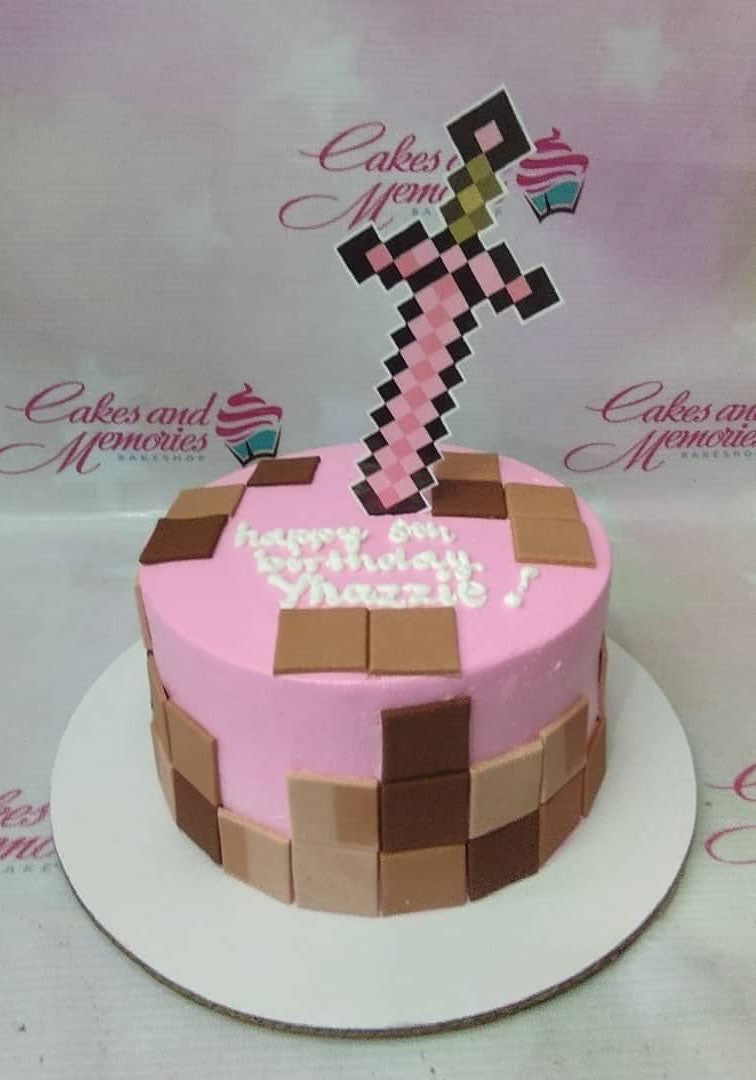 Pink Minecraft themed birthday cake with a pixelated sword topper and brown square fondant accents. Pink Minecraft themed birthday cake with a pixelated sword topper and brown square fondant accents.