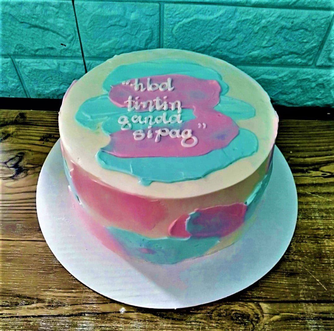 Minimalist bento cake with white icing and abstract pink and light blue palette knife strokes featuring a birthday message.