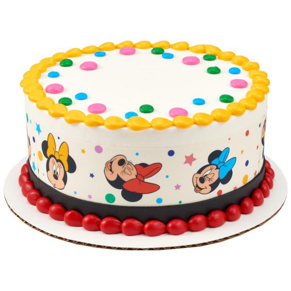 Minnie Mouse themed birthday cake with white icing, colorful dots, and a printed character side wrap. Minnie Mouse themed birthday cake with white icing, colorful dots, and a printed character side wrap.