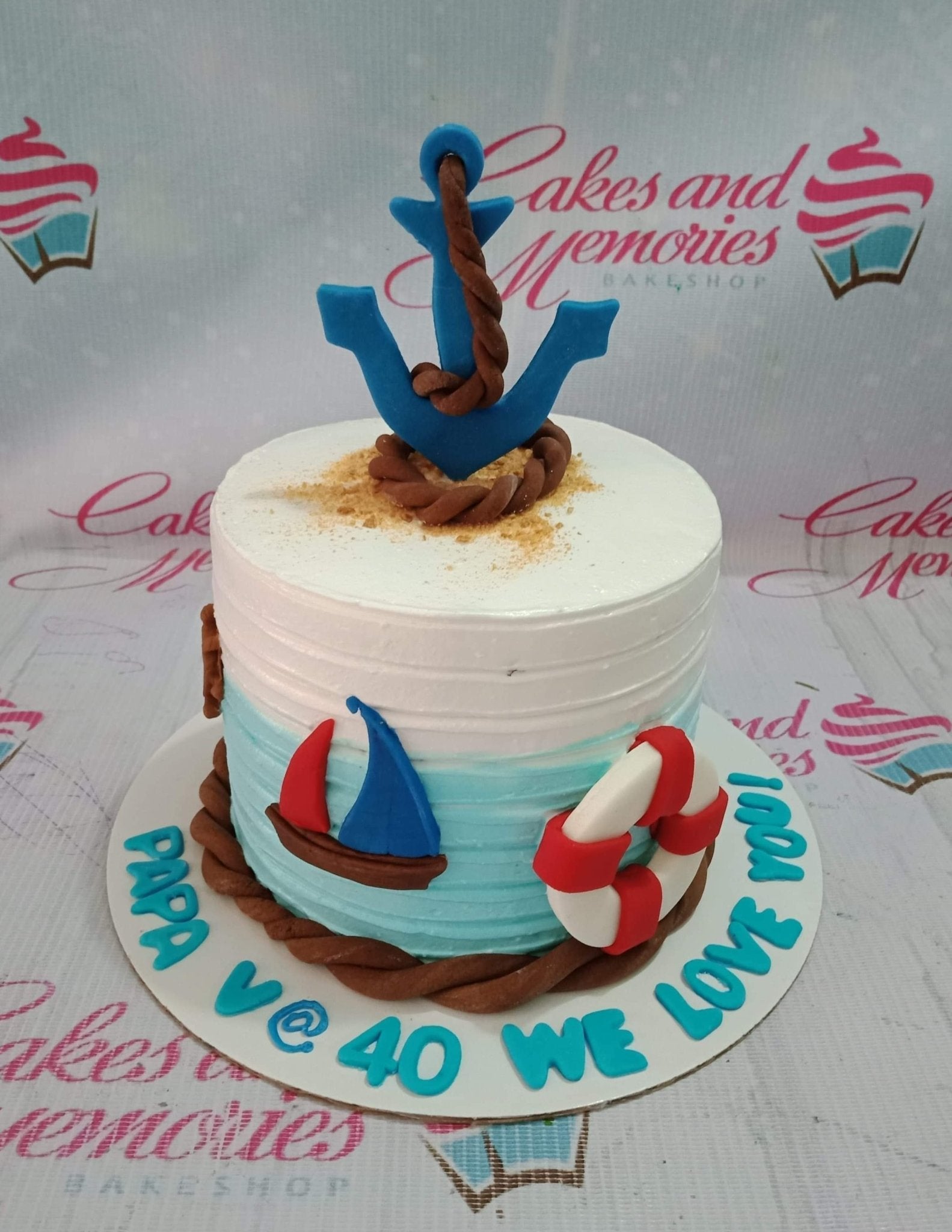 Nautical themed white and light blue cake with a large blue anchor, rope details, a sailboat, and a lifebuoy for a 40th birthday. Nautical themed white and light blue cake with a large blue anchor, rope details, a sailboat, and a lifebuoy for a 40th birthday.