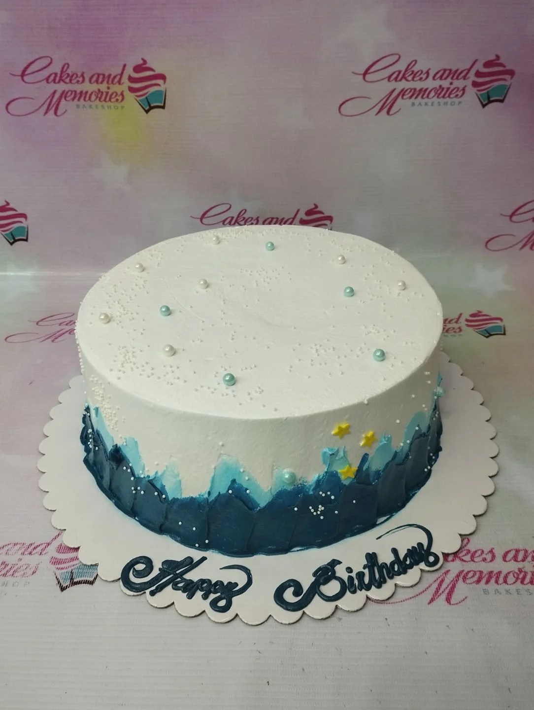 Ocean Minimalist White Cake A white, blue, and yellow 1 Tier cake themed around Ocean Minimalist, featuring blue wave icing, white and light blue pearls, and yellow stars.
