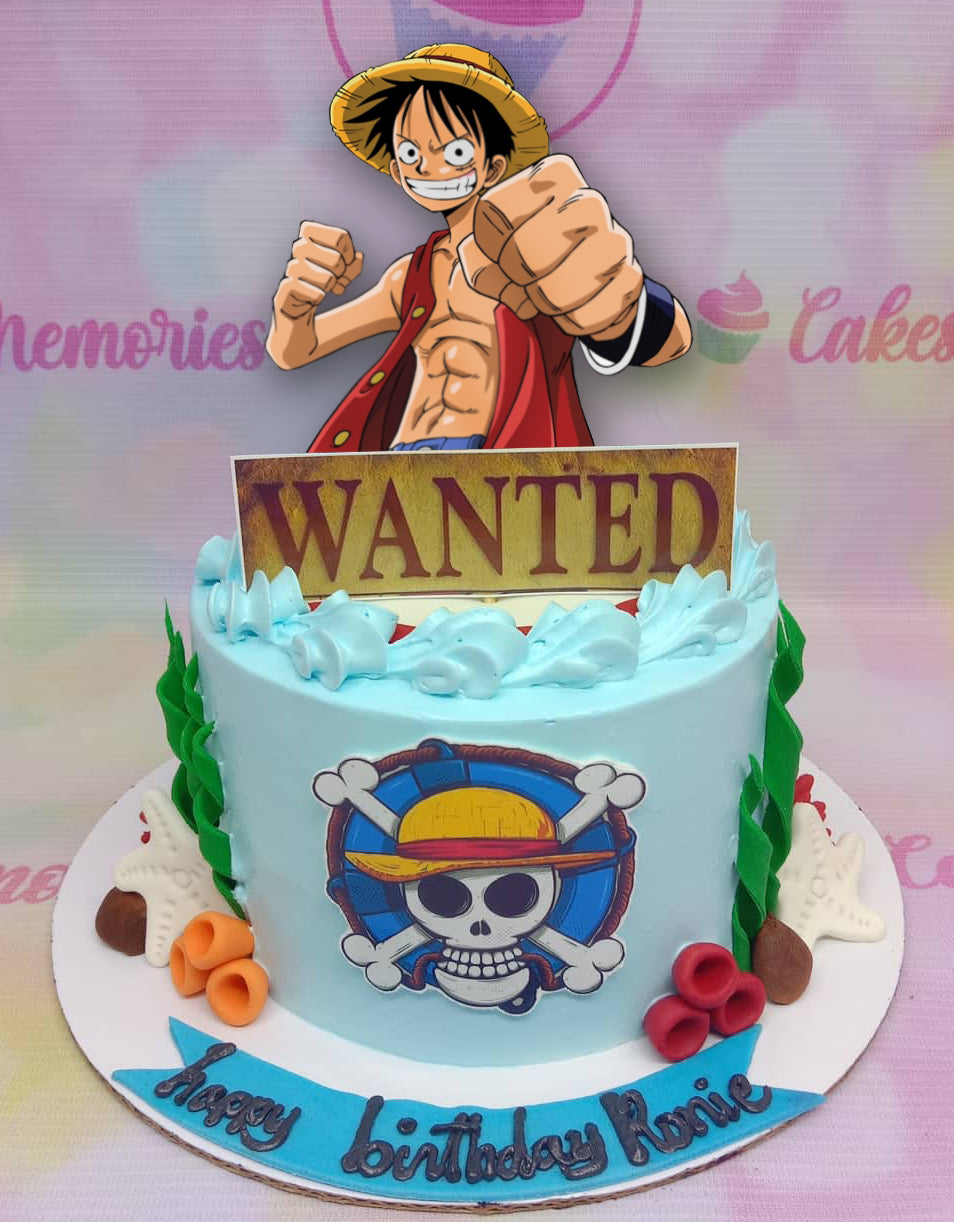One Piece themed light blue birthday cake featuring Luffy and a Wanted poster topper with a Jolly Roger logo on the side. One Piece themed light blue birthday cake featuring Luffy and a Wanted poster topper with a Jolly Roger logo on the side.