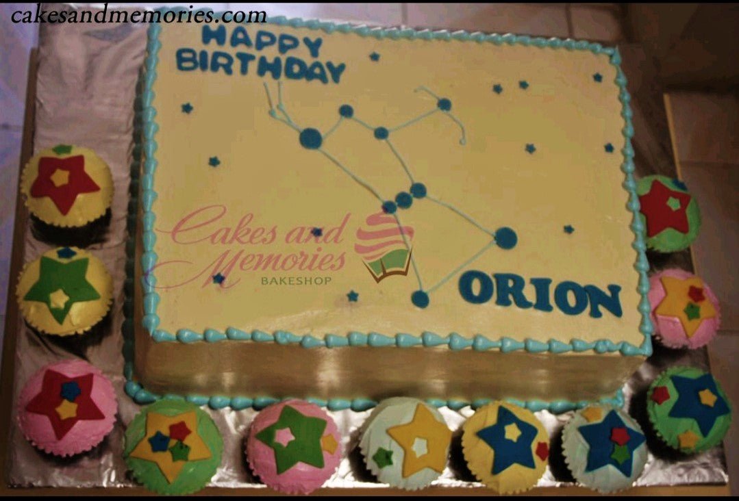 Yellow rectangular birthday cake with blue Orion constellation design, blue icing borders, and matching star-themed cupcakes. Yellow rectangular birthday cake with blue Orion constellation design, blue icing borders, and matching star-themed cupcakes.