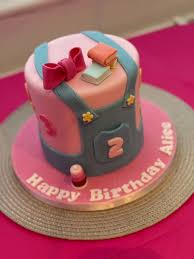 Pink and blue overall-themed fondant cake with a pink bow, books, and a number 2 for Alice's birthday. Pink and blue overall-themed fondant cake with a pink bow, books, and a number 2 for Alice's birthday.