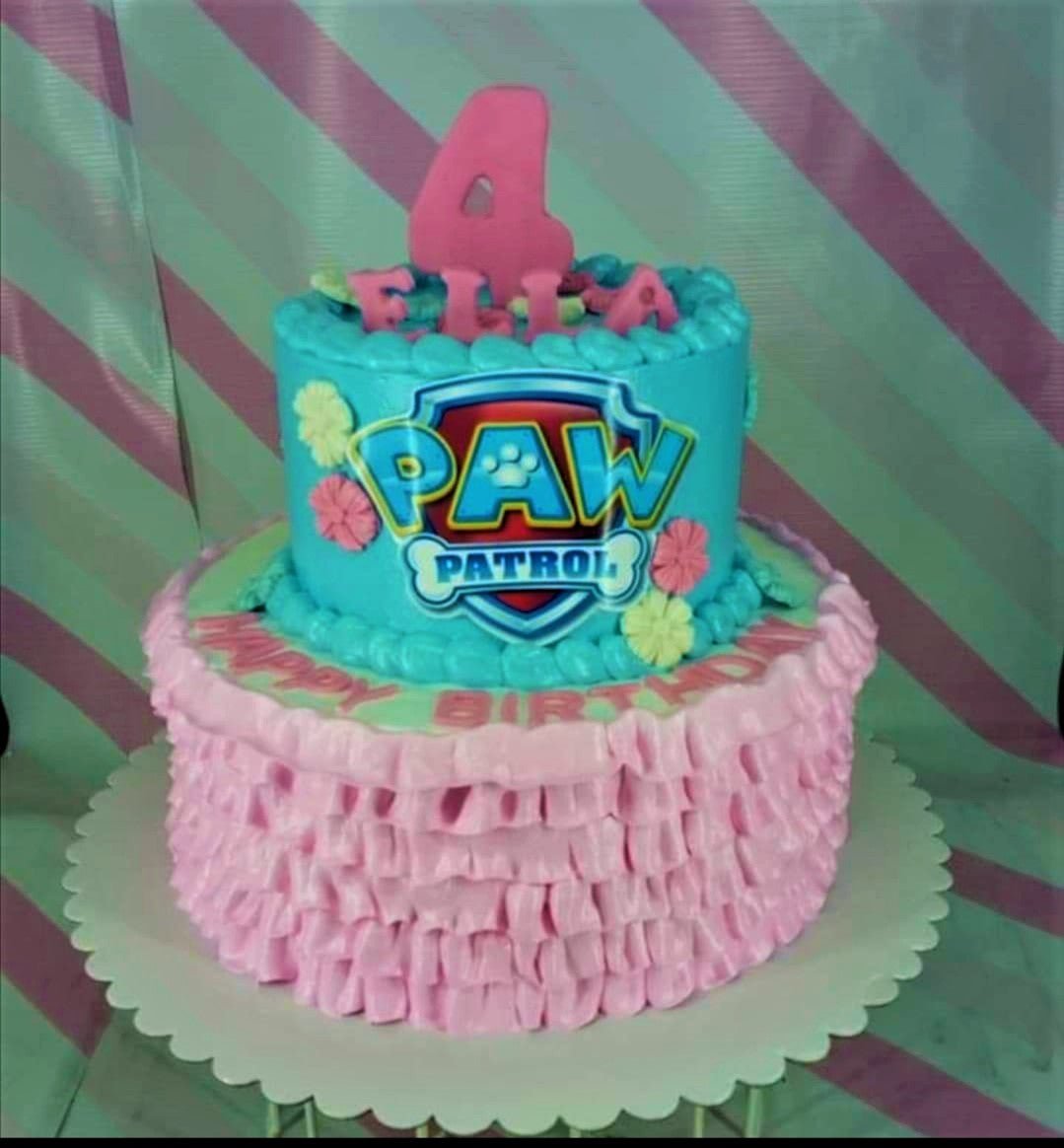 Two-tier Paw Patrol themed birthday cake with blue and pink ruffled icing, featuring a large logo and pink fondant number four topper. Two-tier Paw Patrol themed birthday cake with blue and pink ruffled icing, featuring a large logo and pink fondant number four topper.