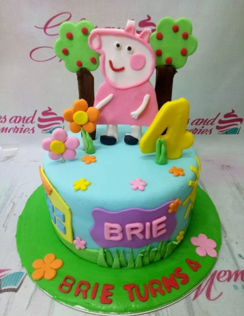 Peppa Pig themed light blue fondant cake with 3D fondant figures of Peppa, trees, and flowers for a 4th birthday.