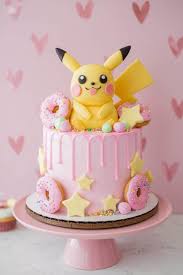 A pink 1 Tier cake featuring a Pikachu figure, pink donuts, yellow stars, and pastel fondant balls. A pink 1 Tier cake featuring a Pikachu figure, pink donuts, yellow stars, and pastel fondant balls.