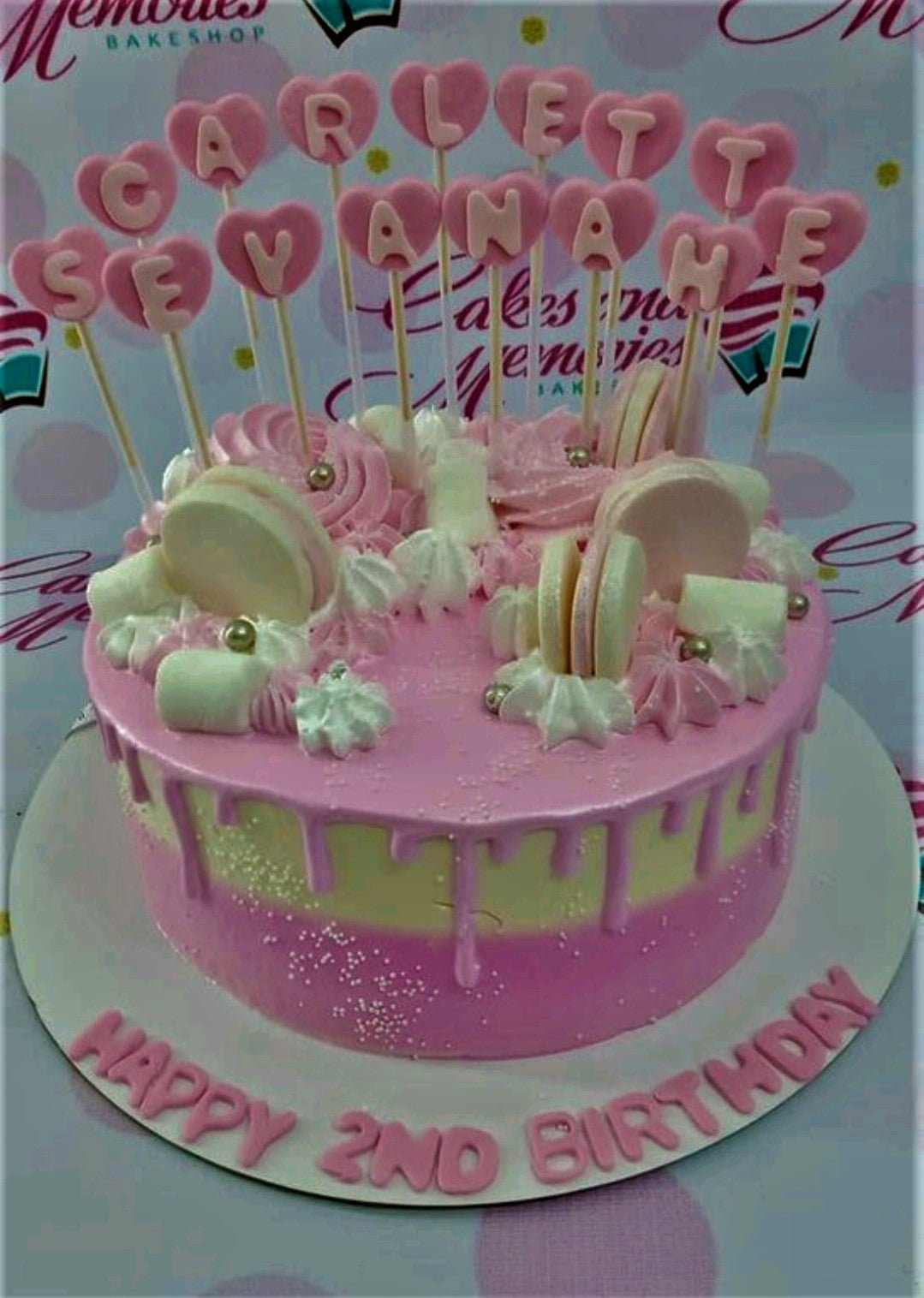 Pink and yellow gradient birthday cake with pink heart toppers, macarons, marshmallows, and gold dragees. Pink and yellow gradient birthday cake with pink heart toppers, macarons, marshmallows, and gold dragees.