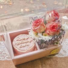Pink bento cake with 'Happy Birthday' message in a clear gift box with fresh pink roses. Pink bento cake with 'Happy Birthday' message in a clear gift box with fresh pink roses.