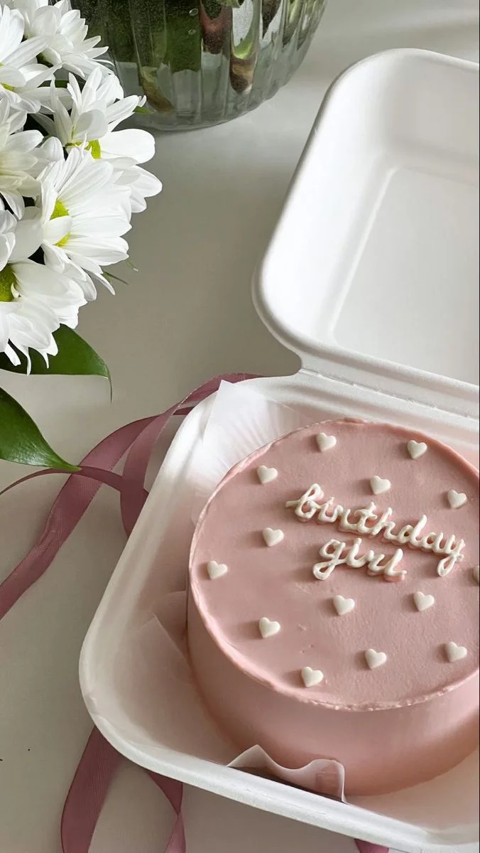 Pink bento cake with white icing hearts and Birthday Girl message in a white takeout box. Pink bento cake with white icing hearts and Birthday Girl message in a white takeout box.