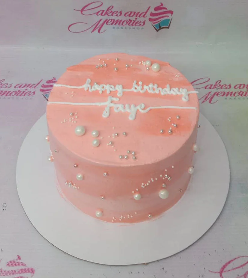 Pink Minimalist Pearl Birthday Cake A pink and white 1-tier cake themed around minimalist birthday, featuring white icing text and silver and white pearl sprinkles.