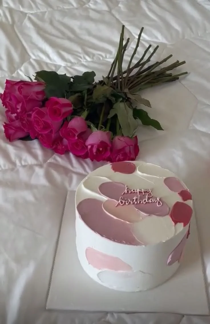 White minimalist cake with pink and lavender palette knife icing strokes and a pink Happy Birthday topper. White minimalist cake with pink and lavender palette knife icing strokes and a pink Happy Birthday topper.