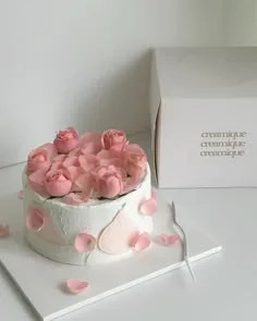 Minimalist white cake with textured icing and pink gumpaste roses and petals on top and sides. Minimalist white cake with textured icing and pink gumpaste roses and petals on top and sides.
